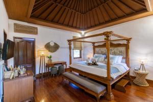 a bedroom with a canopy bed and a television at Vision Villa Resort in Keramas