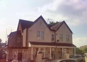 a large white house with a black roof at Vicarage Lodge Birmingham in Birmingham