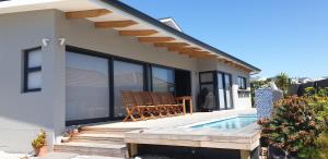 a villa with a swimming pool and a house at Serrulata House in Hermanus