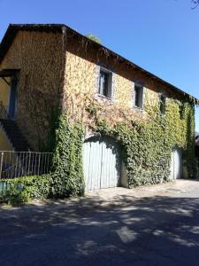 um edifício coberto de hera com um portão branco em Cases Puigcerdà Villaldach em Puigcerdà