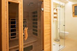 a shower with a glass door in a bathroom at Villa Messner in Funes +80 photos