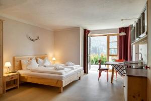 a hotel room with a bed and a table and a kitchen at Villa Messner in Funes
