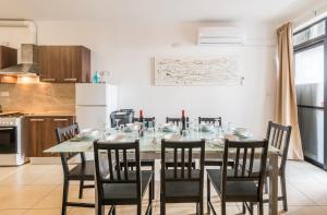 ein Esszimmer mit einem Tisch und Stühlen in einer Küche in der Unterkunft Seashells 2 Bedroom Apartments with terrace, just off the Bugibba promenade - by Getwaysmalta in St Paul's Bay