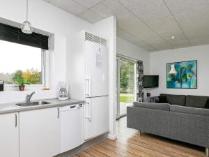 a kitchen and living room with a refrigerator and a couch at 6 person holiday home in Ringk bing in Ringkøbing