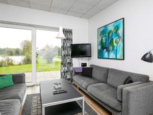 a living room with a couch and a tv at 6 person holiday home in Ringk bing in Ringkøbing