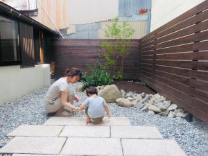 une femme jouant avec un enfant sur les escaliers dans l'établissement Utatei Nada, à Takayama