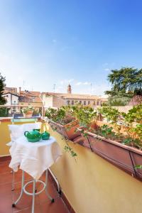 einen Balkon mit einem Tisch und Stühlen auf dem Dach in der Unterkunft Ferrara Be My Guest in Ferrara