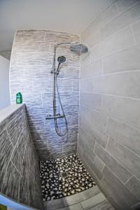 um chuveiro na casa de banho com uma parede de azulejos em "LOUJADE" Maison 3 Chambres à Moncé en Belin - Proche Circuit 24h du Mans em Moncé-en-Belin
