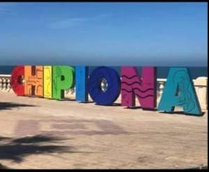 un cartel que dice papaya pintada en la playa en Tabano en Chipiona