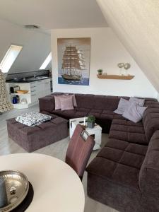 een woonkamer met een bank en een boot aan de muur bij An de Warft Schwalbennest in Büsum