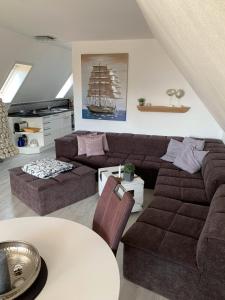 ビューズムにあるAn de Warft Appartement 9 Schwalbennestのリビングルーム(ソファ付)、壁にボートが備わります。