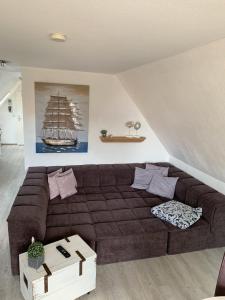 un soggiorno con divano marrone e barca sul muro di An de Warft Schwalbennest a Büsum