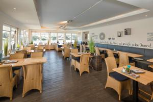 劳恩堡Gästehaus Von Herzen的有木桌椅和窗户的餐厅