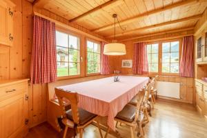 a dining room with a table and some windows at Chalet Cauma in Flims