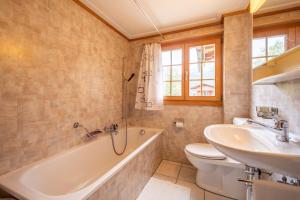 a bathroom with a tub and a toilet and a sink at Chalet Cauma in Flims +3 photos