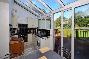 a kitchen with white cabinets and a table with chairs at Cottage 346 - Clifden in Clifden