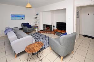 ein Wohnzimmer mit einem Sofa, Stühlen und einem Kamin in der Unterkunft Cottage 346 - Clifden in Clifden