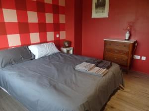 1 dormitorio con 1 cama y pared roja y blanca en BArcoiris B&B - Adults Men only - SOLO PARA HOMBRES en Torrelodones