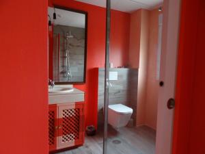 a bathroom with red walls and a toilet and a sink at BArcoiris B&B - Adults Men only - SOLO PARA HOMBRES in Torrelodones