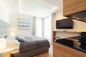 a hotel room with a bed and a flat screen tv at Meridian Luxury Apartments by Grand Apartments in Sopot