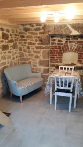 ein Zimmer mit einem Tisch und einem Sofa sowie einem Tisch und Stühlen in der Unterkunft La Boulangerie, charmant cocon pour déconnecter in Montfarville