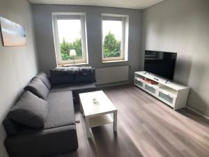 a living room with a couch and a tv at Sanierte 2-Zimmer Wohnung in strandnähe in Kiel