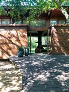 une maison avec deux plantes en pot sur une terrasse dans l'établissement Hideaways Lazuli Bush Lodge, Hluhluwe, à Hluhluwe