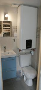 ein Badezimmer mit einem weißen WC und einem Waschbecken in der Unterkunft La Boulangerie, charmant cocon pour déconnecter in Montfarville