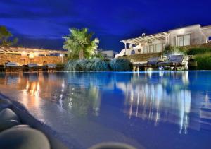ミコノス・シティにあるLeno Villas Mykonosの夜間の家の前の大きなスイミングプール