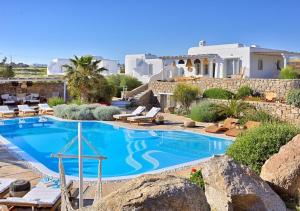 a swimming pool in front of a villa at Leno Villas Mykonos in Mýkonos City