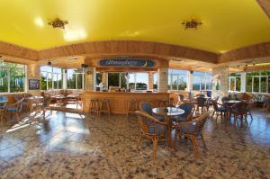 a restaurant with tables and chairs and a bar at Lorenzo Hotel in Lassi