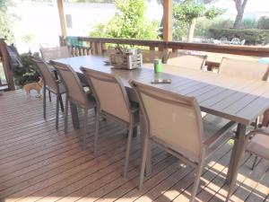 une table et des chaises en bois sur une terrasse dans l'établissement Mobil Home dans camping Lattes, à Lattes