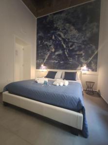 ein Schlafzimmer mit einem großen Bett und einem Gemälde an der Wand in der Unterkunft L'arco e il vico in Neapel
