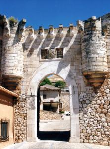 un arco en una pared de piedra con un edificio en Cueva de la Cereria, en Hita