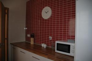 eine Küche mit Mikrowelle und rot gefliester Wand in der Unterkunft Apartamento Costa Ballena in Chipiona + 3 Fotos