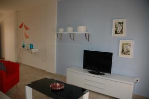 ein Wohnzimmer mit einem TV auf einem weißen Schrank in der Unterkunft Apartamento Costa Ballena in Chipiona