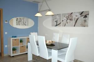 ein Esszimmer mit einem Glastisch und weißen Stühlen in der Unterkunft Apartamento Costa Ballena in Chipiona