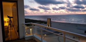 een balkon met een camera en uitzicht op de oceaan bij 7th Heaven Seaview in De Panne