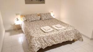 una camera da letto con un grande letto con due asciugamani di Ca la iaia - Turisme familiar ad Amer