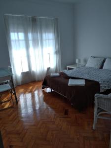 1 dormitorio con 1 cama y suelo de madera en Belém Cozy Bedroom, en Lisboa