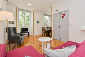un soggiorno con un divano viola e un tavolo di Oeiras 2 - Checkinhome a Oeiras