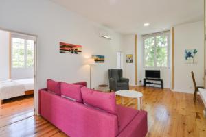 un soggiorno con divano rosa e tavolo di Oeiras 2 - Checkinhome a Oeiras