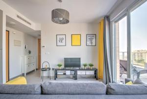 a living room with a couch and a tv at Apartment BlueHat Moncofa in Moncófar