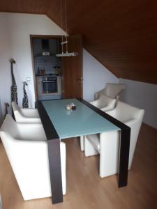 a dining room with a blue table and white chairs at Ferienwohnung Steffi in Andernach +15 photos