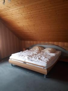 Ferienwohnung Steffi في أندرناخ: سرير في غرفة ذات سقف خشبي