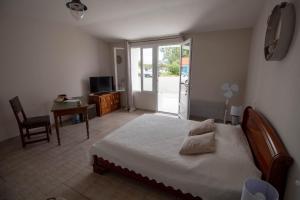 Un dormitorio con una cama, un escritorio y un televisor. en La Sornière, en Talmont
