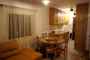 a living room with a table and a kitchen at Mountain house Vilina rosa in Kolašin