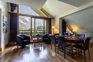 une salle à manger avec une table, des chaises et une grande fenêtre dans l'établissement Les Balcons du Savoy, à Chamonix-Mont-Blanc