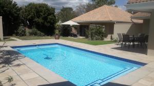 a swimming pool in the backyard of a house at Cottage@Somerset in Somerset West