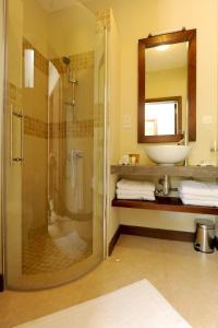 a bathroom with a shower and a sink and a mirror at Athena Villas by Fine & Country in Grand Baie